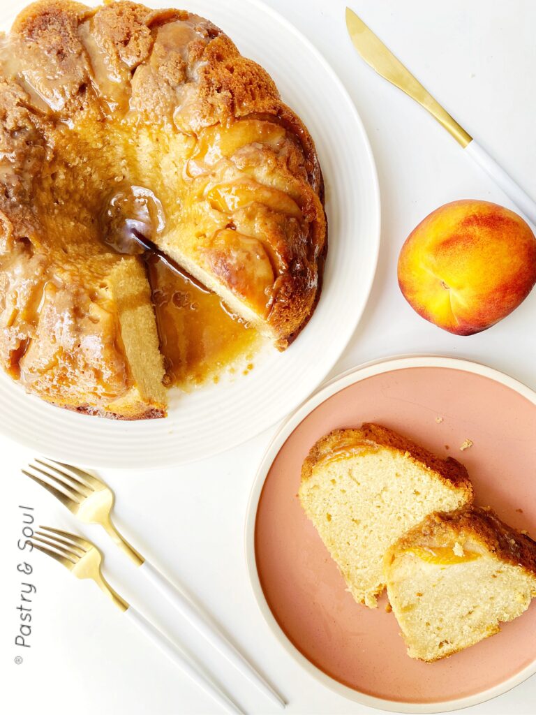 rum cake on a pink and white plates with a whole peach