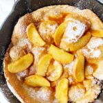 Dutch Baby Pancake in a cast iron skillet with apples in caramel sauce