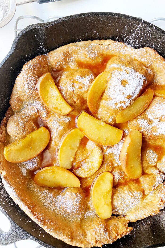 Dutch Baby Pancake in a cast iron skillet with apples in caramel sauce