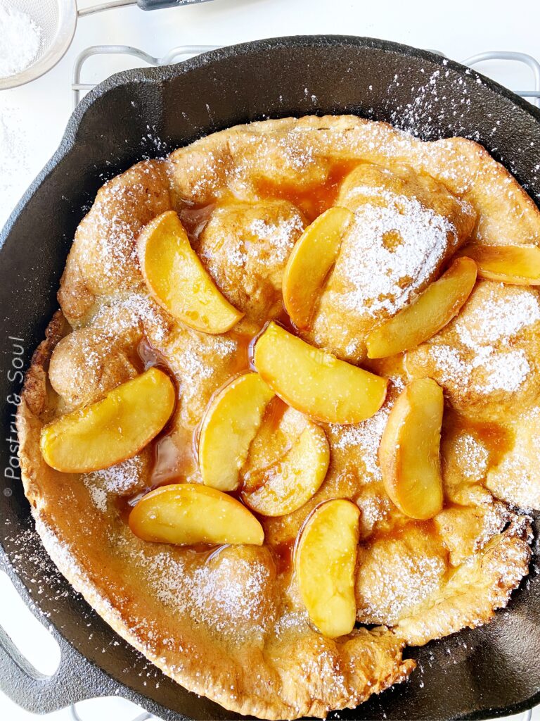 Dutch Baby Pancake in a cast iron skillet with apples in caramel sauce